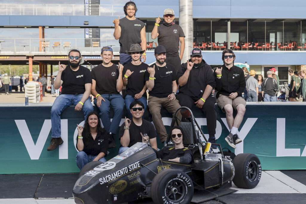 Members of the Sacramento State Hornet Racing team pose for photos with their race cars.